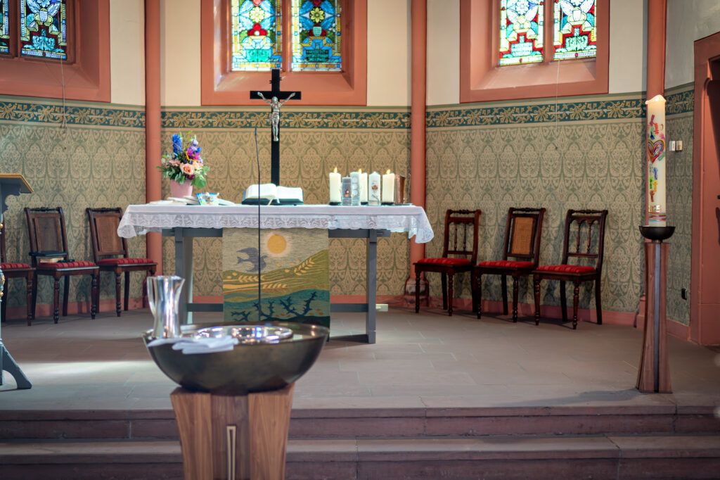 Blick auf Altar, Taufbecken und Taufkerze bei einer katholischen Taufe in Hanau