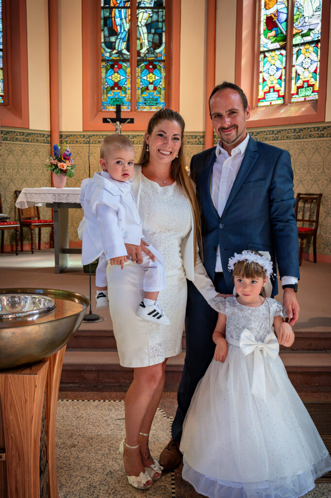 Eltern mit Taufkind und Geschwisterkind in der Kirche bei der Taufe im Rhein-Main-Gebiet
