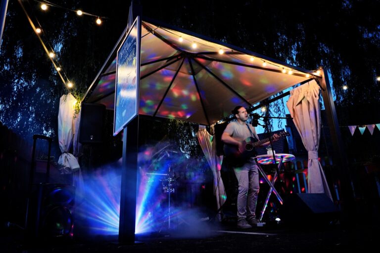 Liveband spielt auf Sommerfest unter Lichterkette mit Gitarre und Nebel
