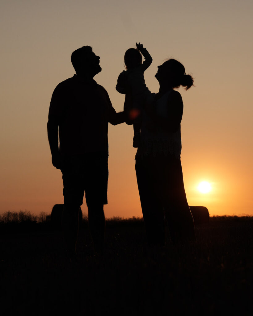 Familie blickt gemeinsam auf den Sonnenuntergang – Outdoorshooting im Feld bei Hanau