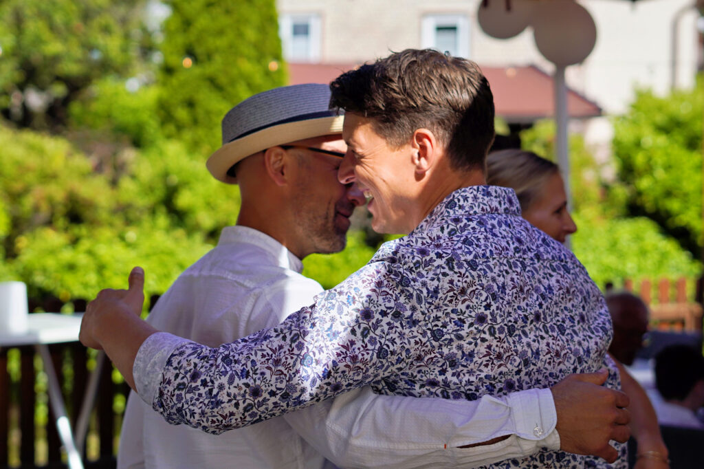 Zwei Freunde umarmen sich herzlich bei einer Gartenfeier im Main-Kinzig-Kreis &ndash; echte Eventfotografie von Dennis Herzberger.