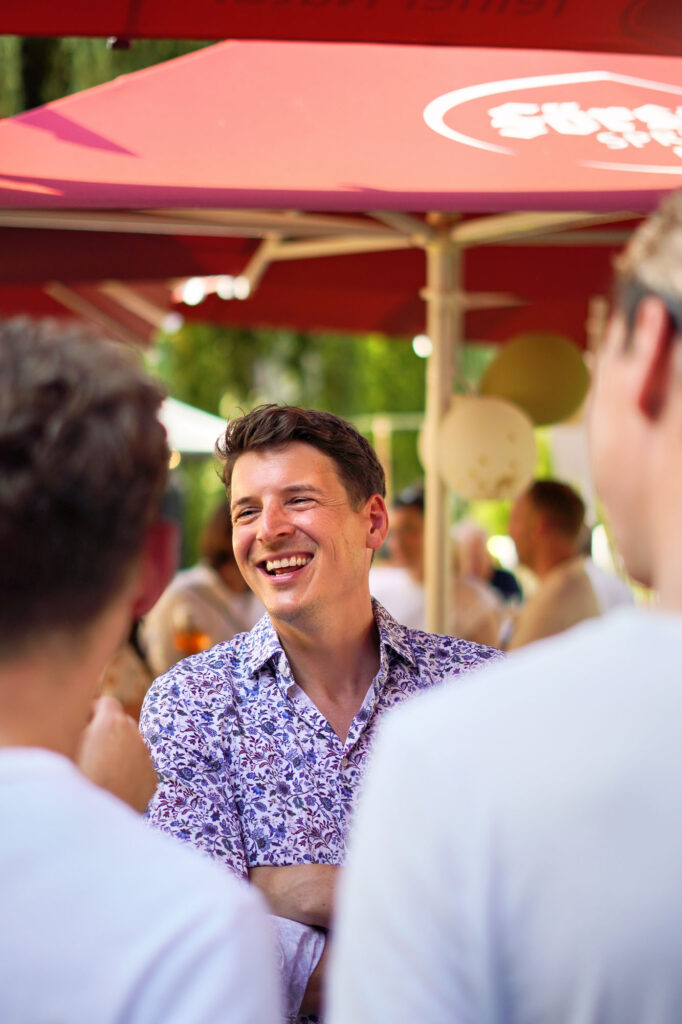 Lächelnder Mann im Gespräch bei Sommerfeier im Main-Kinzig-Kreis – festgehalten von Dennis Herzberger.