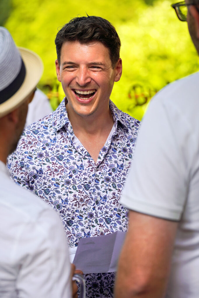 Fröhlicher Mann lacht im Gespräch bei privater Feier im Rhein-Main-Gebiet – echter Moment voller Emotion.