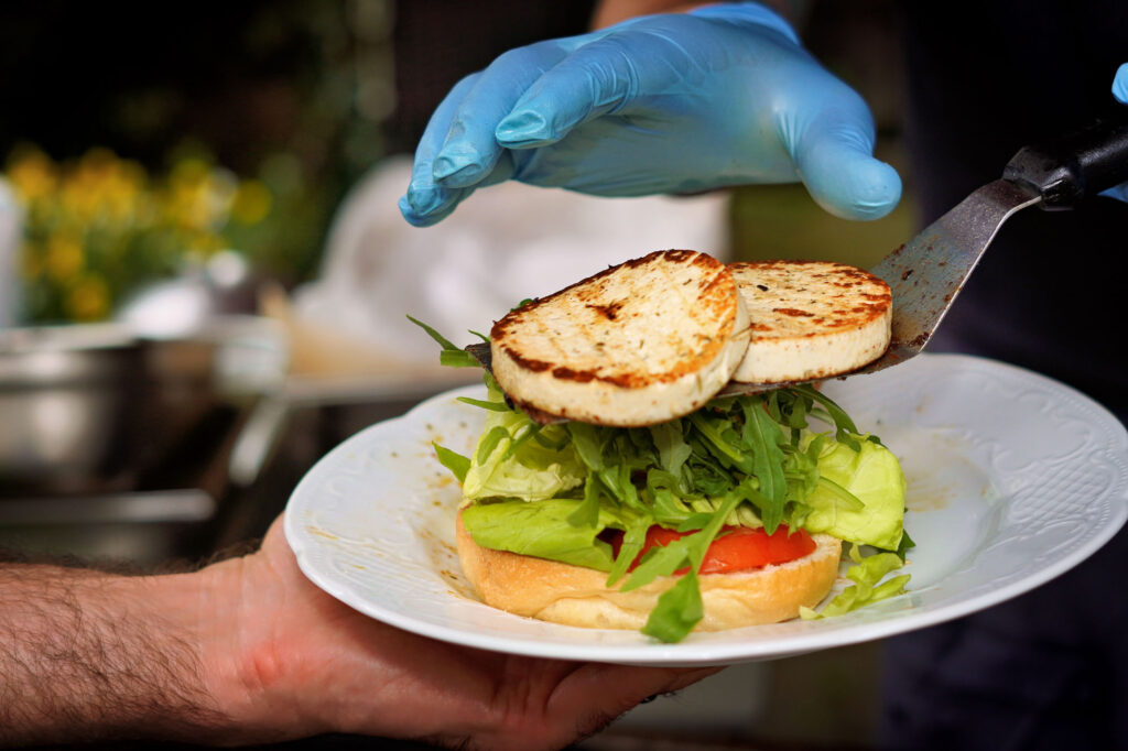Halloumi-Burger auf weißem Teller bei Gartenfeier im Main-Kinzig-Kreis – Food-Foto mit sommerlicher Note.