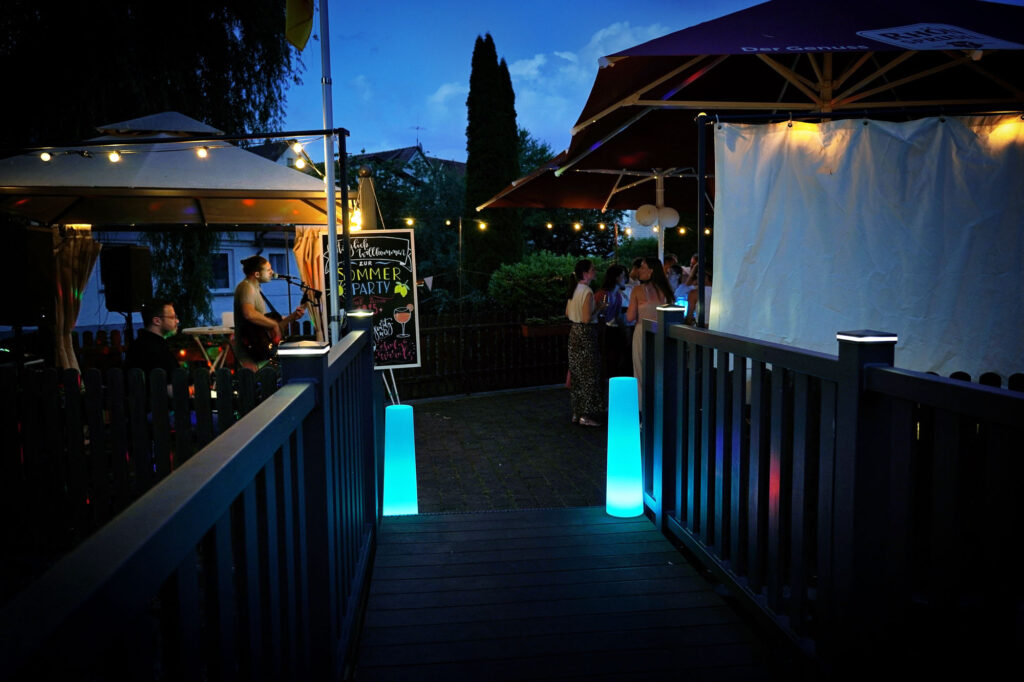 Eingang zur Sommerparty mit Lichterkette und Live-Musik in Bruchköbel – einladende Eventatmosphäre.