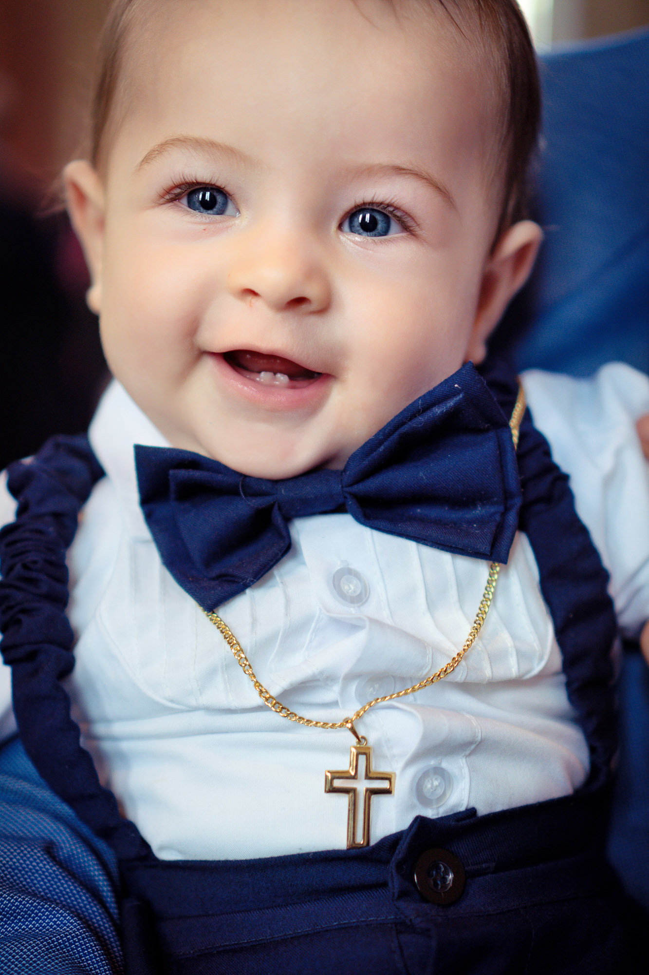 Nahaufnahme Baby mit goldener Taufkette und Schleife