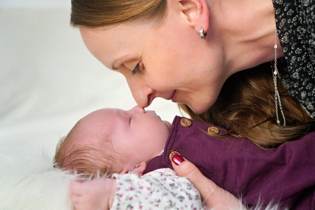 Mama berührt mit der Nase ihr Baby – emotionales Newbornfoto in Bruchköbel