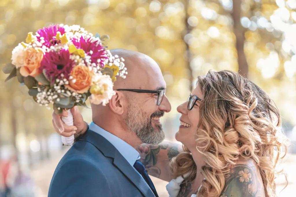 Brautpaar in inniger Umarmung mit bunten Blumen im Boho-Stil